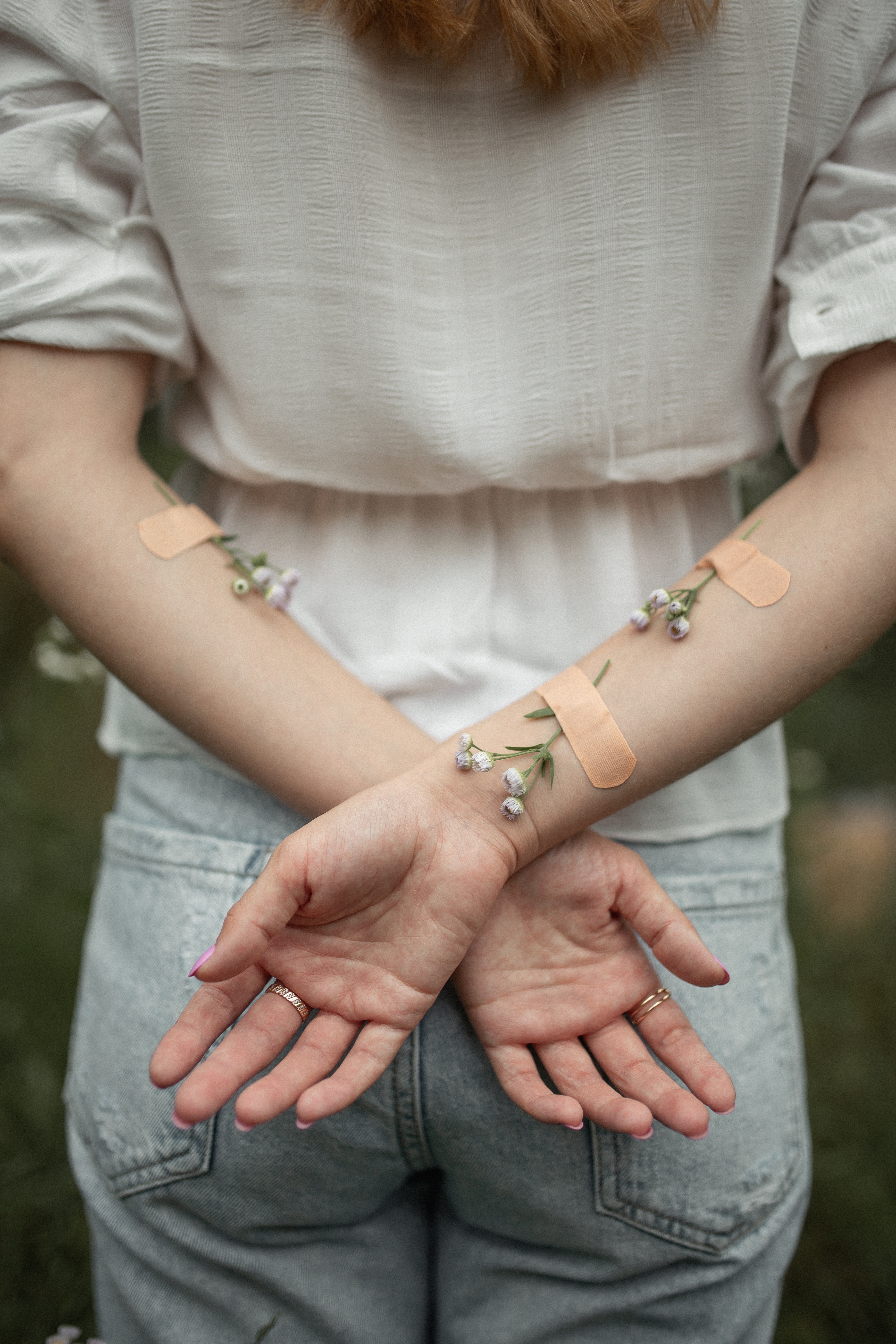 woman's arms with bandaids and flowers