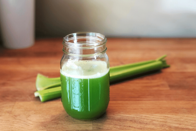 cup of celery juice next to stalk of celery