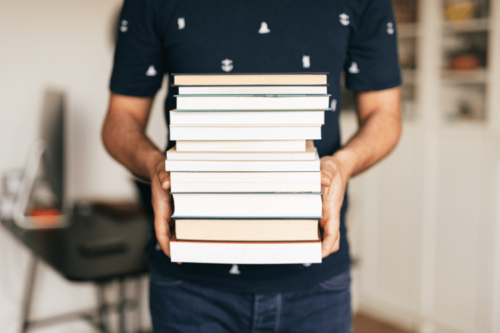 Man holding a stack of books